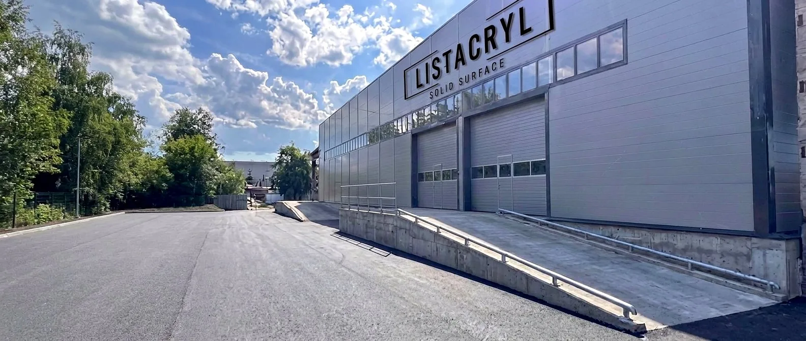 Façade of the LISTACRYL production building in Kirishi with the brand sign on the wall