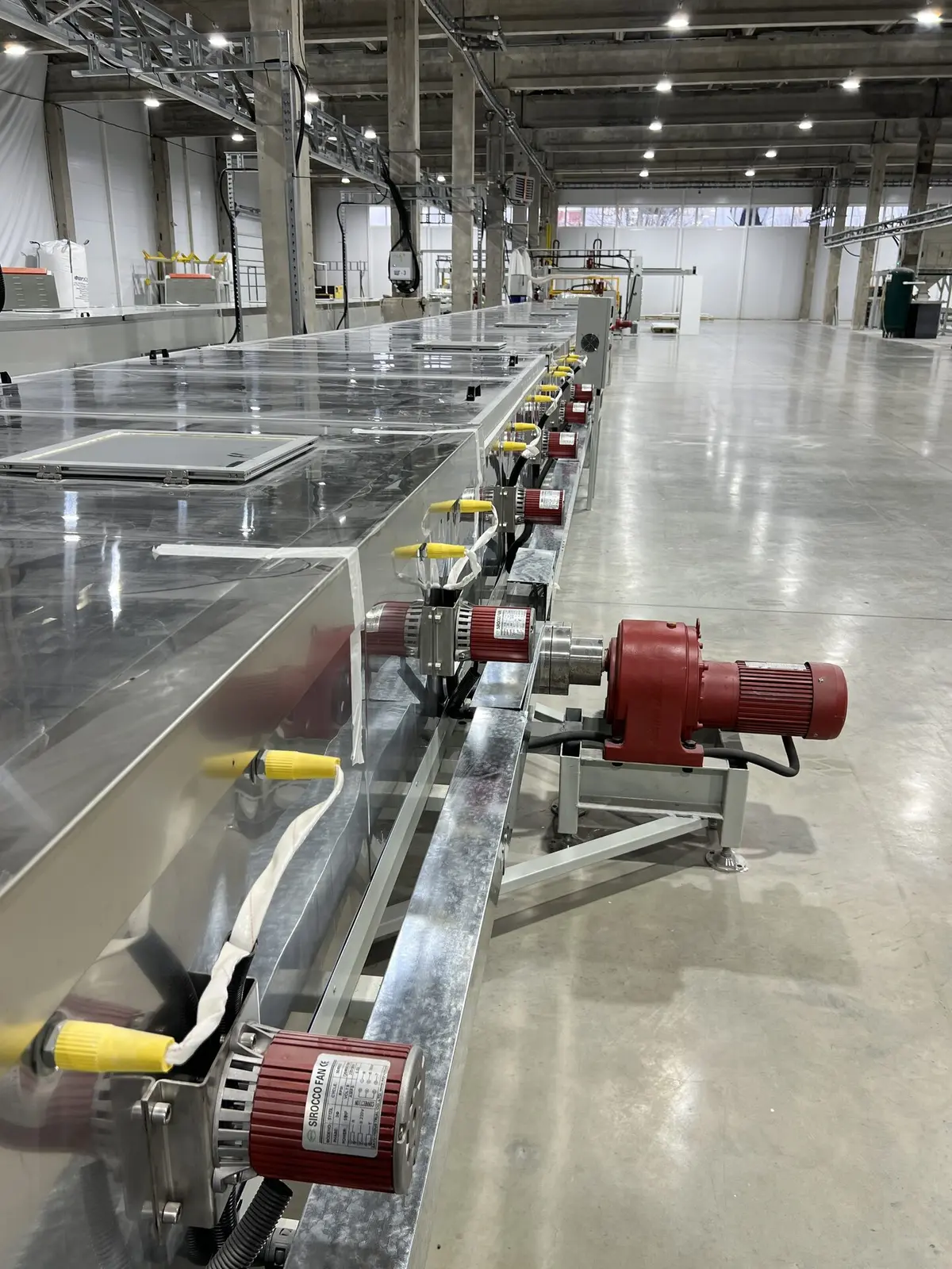 Roller conveyor drives on the LISTACRYL line — the transport section carrying the acrylic web