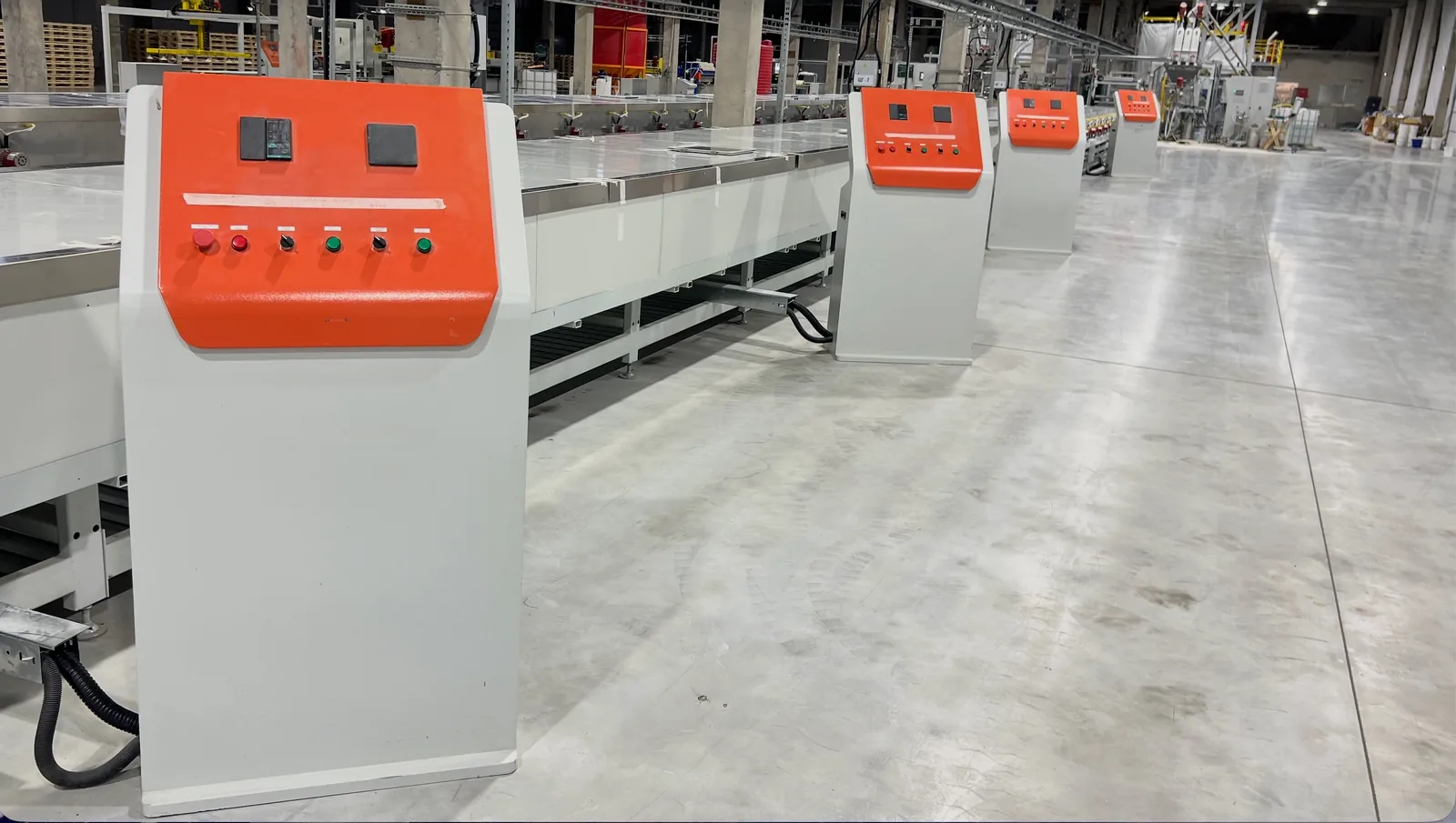 Orange control desks along the LISTACRYL sheet line, each governing one section of the conveyor